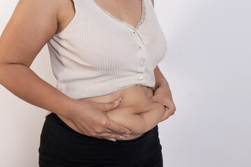 Overweight woman hand pinching excessive belly fat on gray background, Healthy concept