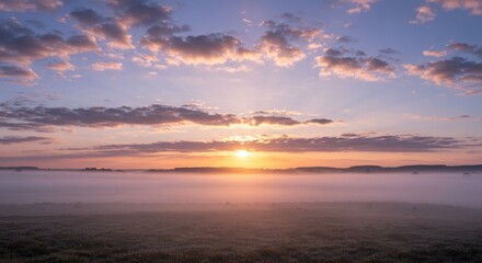 Fototapeta premium Light mist rising under scattered clouds at sunrise