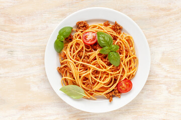 Pasta Spaghetti Bolognese in white plate on wooden background. Bolognese sauce is classic italian...