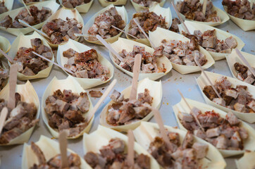 paper stick with small pieces of meat to serve in the catering of a celebration.