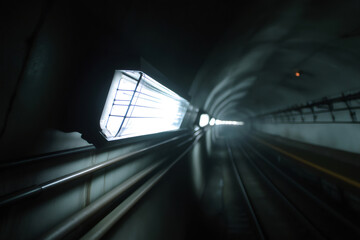 Flickering emergency light illuminates a dark subway tunnel, creating a mysterious and eerie atmosphere