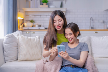Asian friend Young women talking self-portrait with camera phone on sofa Happy young woman showing...