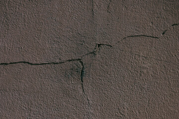 Close examination of a cracked gray wall surface in urban setting showcasing texture details