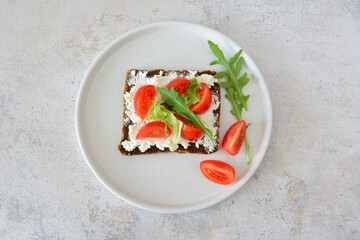 Delicious and healthy toast with tomatoes, cheese and arugula top view