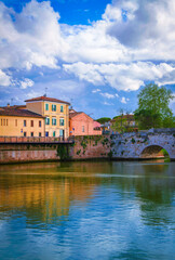 Obraz premium Beautiful Rimini city skyline and landscape over the landmark bridge Ponte di Tiberio and the Marecchia River in the Emilia-Romagna region of Italy, blending ancient charm with scenic beauty