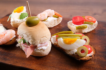 Primo piano di panino e tartine sul tagliere di legno