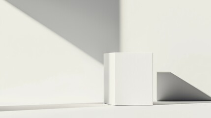 A white cube with a textured surface stands against a white wall, casting a shadow on the floor.