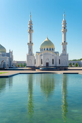 Beautiful view of white mosque with reflection in water. Russia