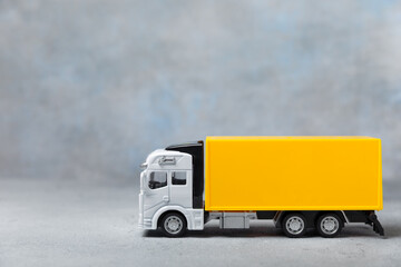 Yellow forklift on bright textured background. Logistics concept. Logistics and supply chain management for online shopping concept. Delivery of goods or products to the store worldwide. Cardboard box