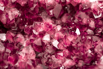 Amethyst garnet crystals. Burgundy gemstone. Mineral crystals in the natural environment. Texture of precious and semiprecious stones. Colored shiny surface of precious stones.