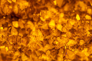 Golden crystal mineral stone. Gems. Mineral crystals in the natural environment. Texture of precious and semiprecious stones. Seamless background with copy space.