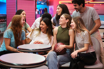 Happy friends enjoying time together at the bowling alley, laughing and having fun