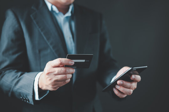 businessman hold credit card and use smartphone to buy or purchase produce payment online. The concept of finance and online shopping.