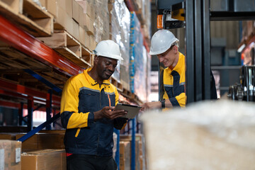 Male warehouse worker driver in forklift electric discussing with colleague worker holding tablet checking stock products on shelves at warehouse factory store. Logistics, Distribution Center concept