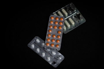 Pills in blister packs on a black background