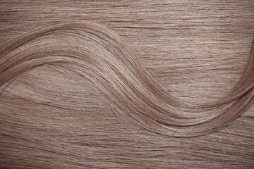 Blond hair close-up as a background. Women's long light brown hair. Beautifully styled wavy shiny...