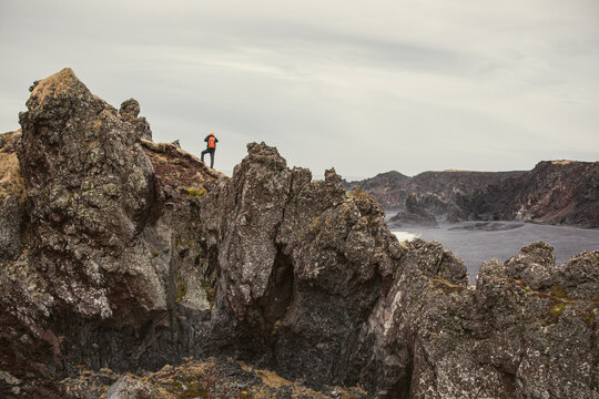 Man Exploring and Photographing Iceland&rsquo;s Black Sand Beach