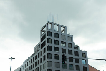 Fototapeta premium A modern contemporary building design set against a dramatic overcast sky, ideal for themes related to urban architecture
