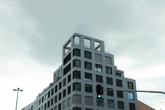 A modern contemporary building design set against a dramatic overcast sky, ideal for themes related to urban architecture