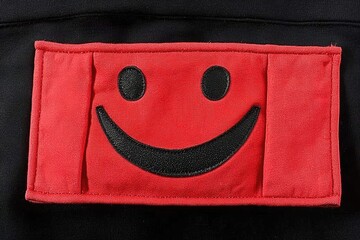 Red patch with happy face on black fabric background
