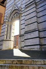 Fototapeta premium Filtering light through a gate nearby Siena Cathedral, Tuscany, Italy