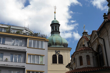 Fototapeta premium A beautiful and scenic view showcasing a church tower alongside contemporary modern buildings set against a cloudy sky