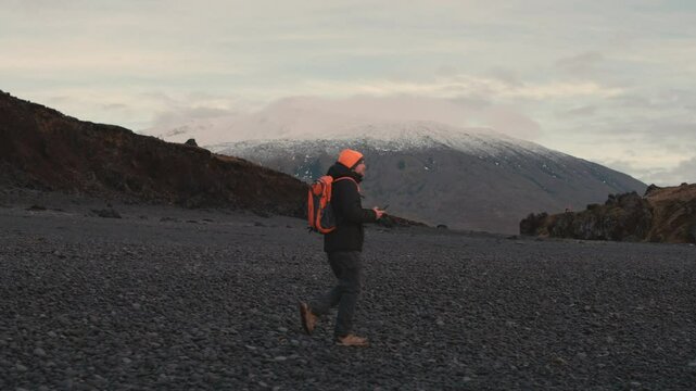 Man Exploring and Photographing Iceland&rsquo;s Black Sand Beach