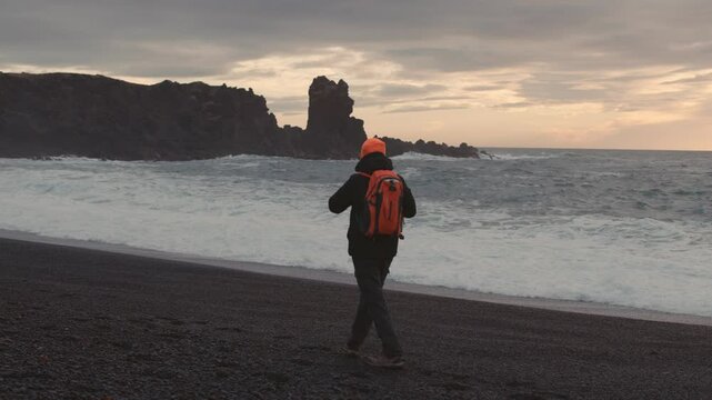 Man Exploring and Photographing Iceland&rsquo;s Black Sand Beach