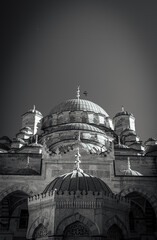 The majestic Yeni Camii (New Mosque) in black and white, a significant landmark of Ottoman architecture with the mosque's impressive array of domes, from the large central one to the smallest.