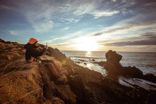 Man Exploring and Photographing Iceland&rsquo;s Black Sand Beach