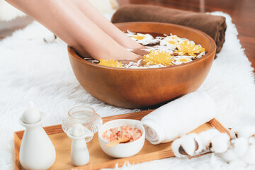 Woman indulges in blissful foot massage at luxurious spa salon while masseur give reflexology therapy in gentle day light ambiance resort or hotel foot spa. Quiescent