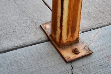 Rusted bracket secured to cement.