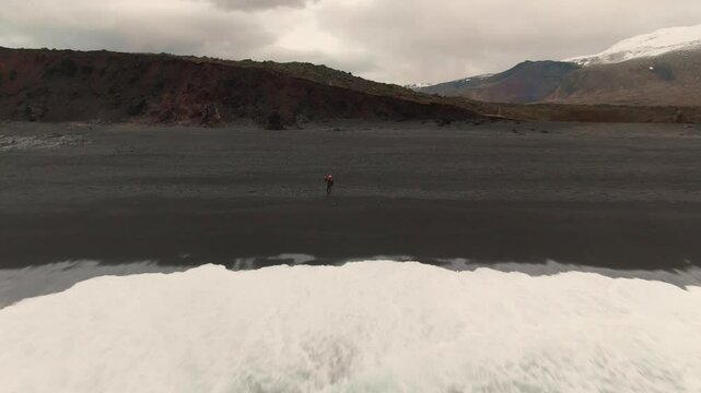 Man Exploring and Photographing Iceland&rsquo;s Black Sand Beach