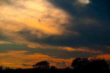 Fiery sunsets over a forested landscape, with the sky ablaze in warm hues, creating a dramatic and breathtaking scene.
