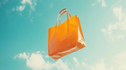 Bright orange shopping bag floating against a clear blue sky with soft clouds in the background