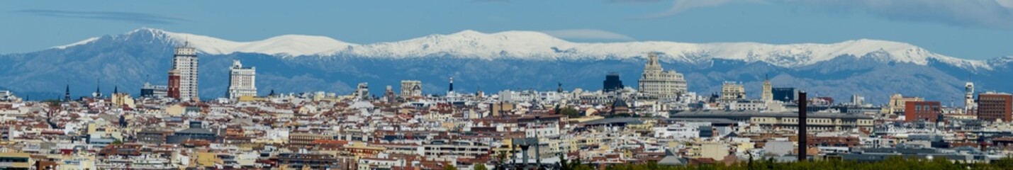 Panoramic view of Madrid, the capital of Spain, with the partially snow-covered mountains in the background.