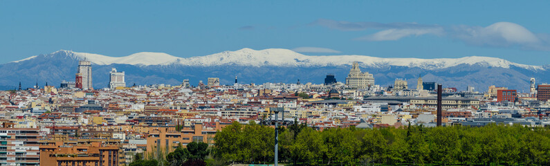 Fototapeta premium Panoramic view of Madrid, the capital of Spain, with the partially snow-covered mountains in the background.