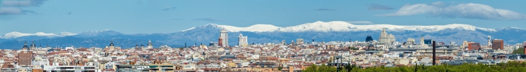 Panoramic view of Madrid, the capital of Spain, with the partially snow-covered mountains in the...