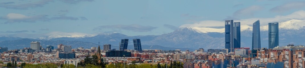 Panoramic view of Madrid, the capital of Spain, with the partially snow-covered mountains in the...
