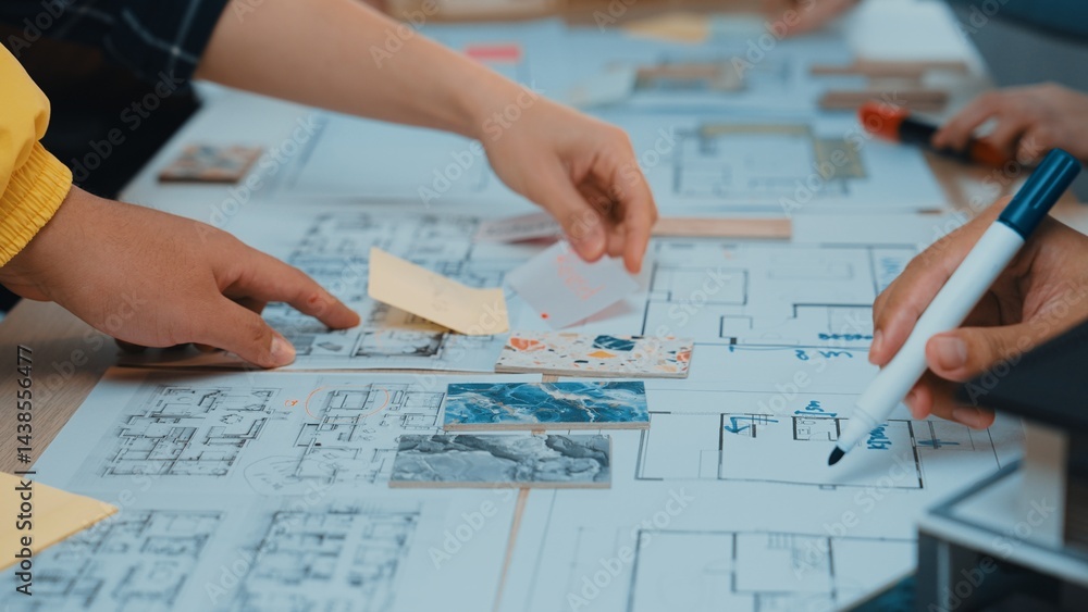 Poster hands engage in collaborative brainstorming over architectural plans and sketches, showcasing teamwo