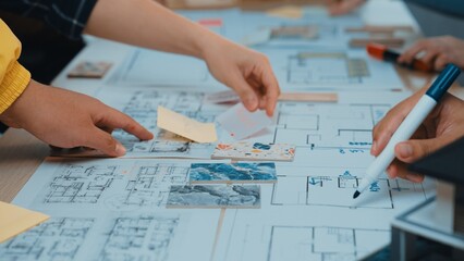 Hands engage in collaborative brainstorming over architectural plans and sketches, showcasing teamwork and creativity in a dynamic workspace filled with notes and drawings. SACTR