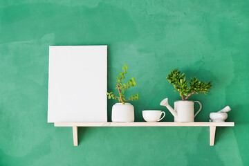 white canvas frame mockup for painting on shelf with decoration objects, rustic green wall © dark_blade
