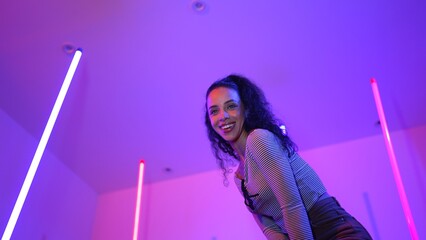 Low angle camera of hispanic dancer looking at camera and dancing to city pop music. Professional...