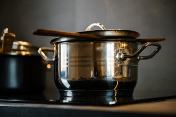 Cooking pots on induction cooktop in the kitchen, food preparation concept