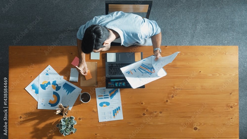 Poster skilled businessman writing idea on colorful sticky notes while looking at data analysis. caucasian 
