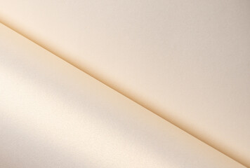 Paper texture with creamy beige and light pink tones, glossy pearlescent surface with shimmering...