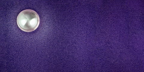 Purple abstract background with decorative plaster and round lamp. Texture of decorative plaster. Copy space.