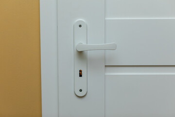 An elegant white door handle that features a sophisticated lock mechanism for added security