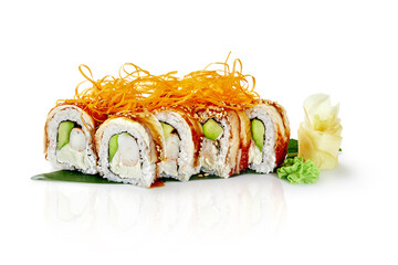 Sushi rolls with eel, avocado, cream cheese, shrimp and sesame seeds lying on a banana leaf