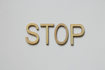 Wooden letters forming the word stop on a white background, stop